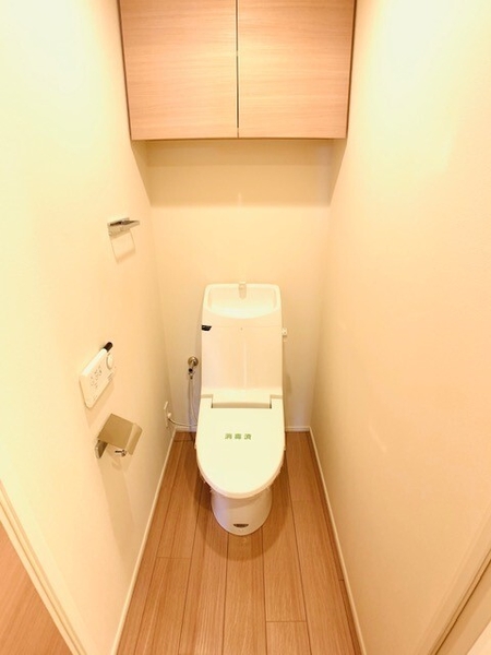 便利な吊戸棚付きのトイレ。収納力を確保し、清潔感のある空間を演出します。