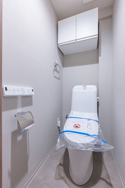 【トイレ】清潔感のあるトイレは、温水洗浄機能付暖房便座採用。吊戸棚には消耗品が収納できて便利。