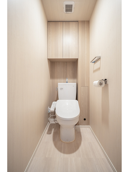 清潔感のあるトイレ空間。吊戸棚収納を備え、トイレットペーパーや掃除用品の収納にも便利です。