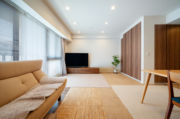 【リビング】ダウンライトの温かみのあるお部屋。フローリングは傷がつかないようシートでカバー