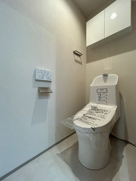 清潔感のあるトイレは、消耗品が収納できる吊戸棚付きで便利です。