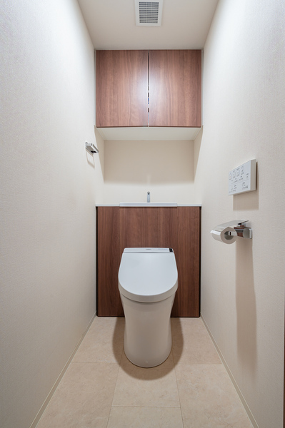 清潔感のあるトイレは、温水洗浄便座を採用。吊戸棚には消耗品が収納できて便利です。