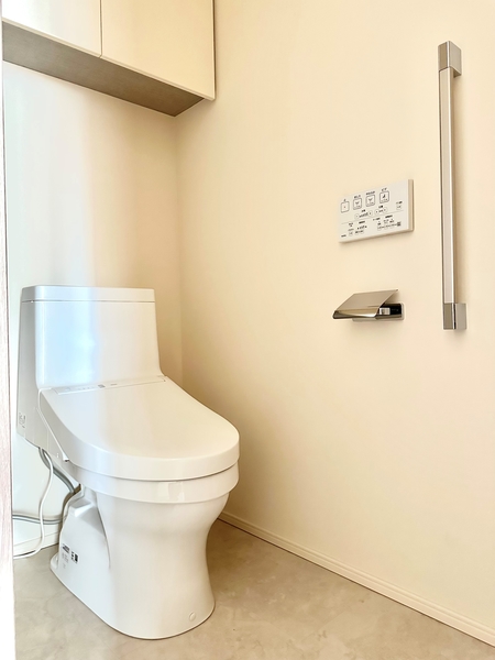 手洗い器付トイレは、ウォッシュレット一体型。ペーパーや衛生用品を収納しておける吊戸棚がございます。
